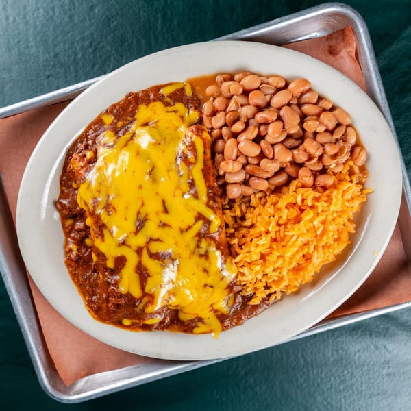 Ace's BBQ enchiladas covered in melted cheese, served with pinto beans and orange rice.