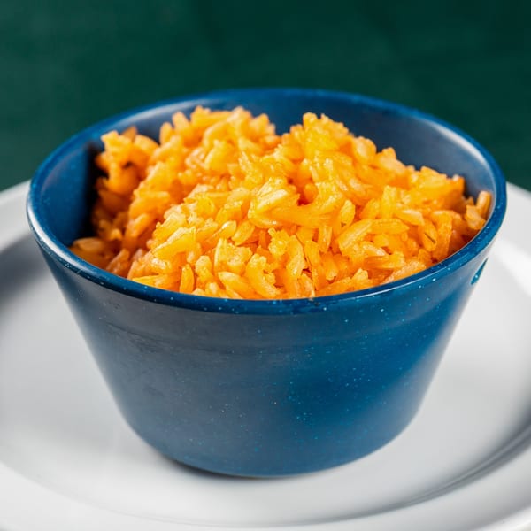 A blue bowl filled with bright orange rice, a side dish from Ace's BBQ.
